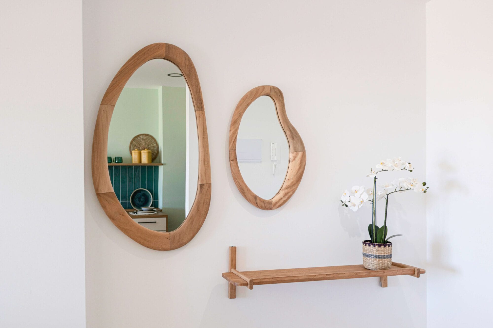 Recibidor de vivienda con espejo de madera moderno y estantería